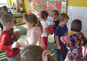 Dzieci tańczą w parach z balonem pomiędzy nimi